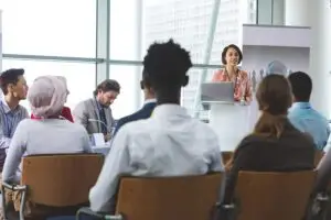 Female speaker with laptop speaks in a business seminar