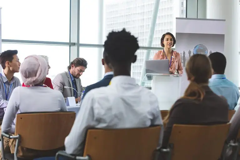 Female speaker with laptop speaks in a business seminar